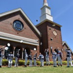 graduating class tossing hats in front of chapel