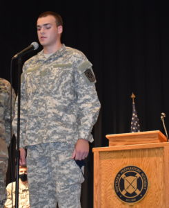 young man in camo speaking at microphone