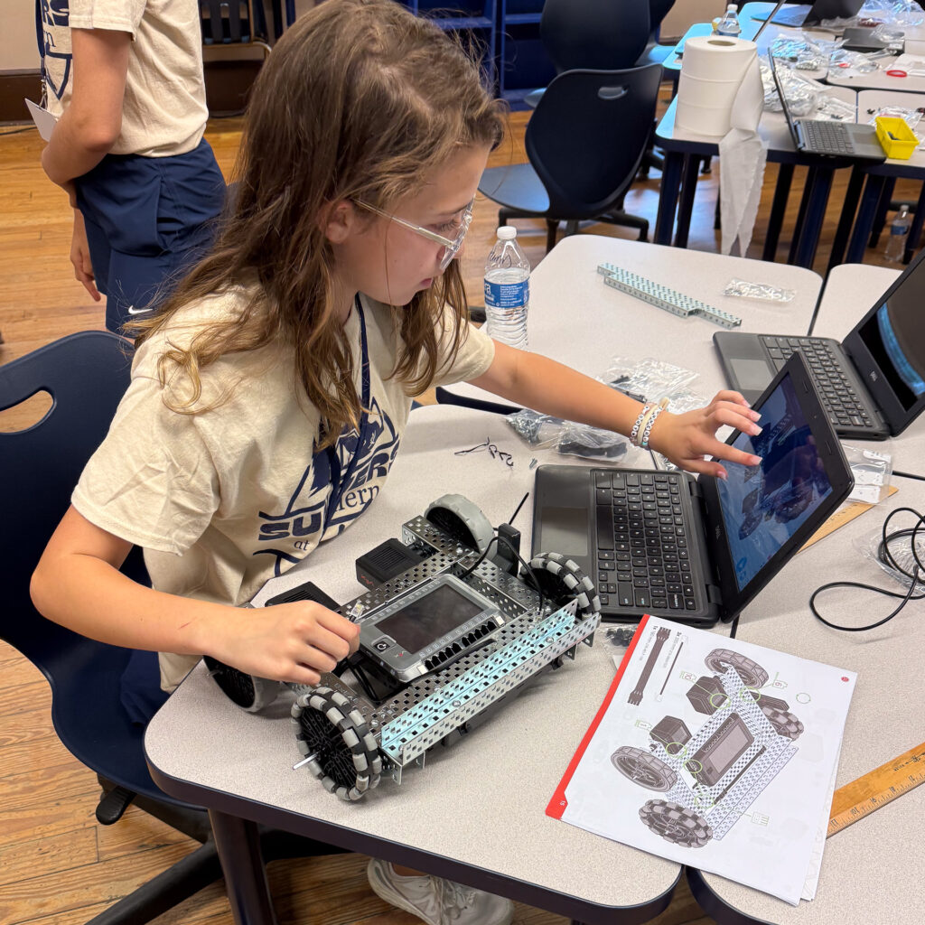A female Summers at Southern camper works on her VEX Robot.